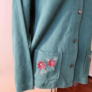 Cardigan sweater front pockets with machined poinsettia and holly embroidery
